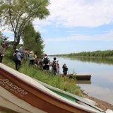 Un grupo de personas se reúne a la orilla del río en el Paraje La Boca en el barrio santafesino del distrito de la costa Alto Verde.
